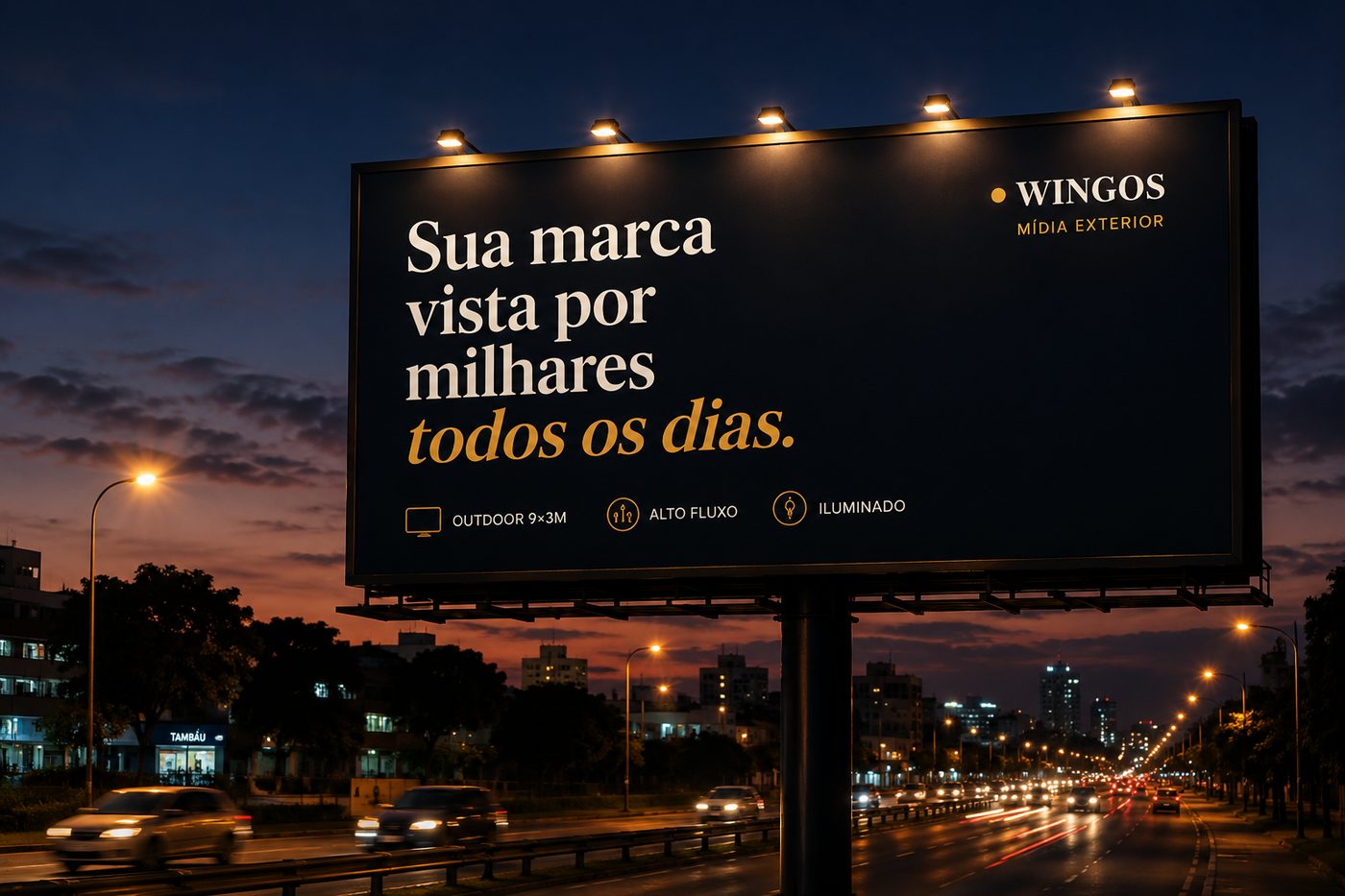 Outdoor 9×3m da Wingos iluminado em avenida de alto fluxo ao entardecer